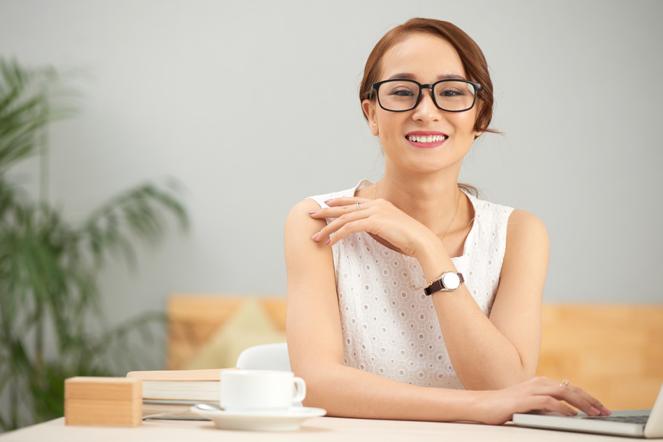 Portrait of smiling elegant business lady in glasses looking at camera